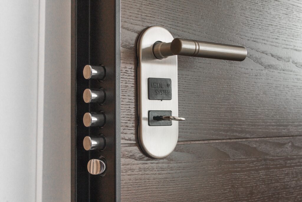 Cerradura de seguridad reforzada con llave puesta en una puerta metálica de entrada a una vivienda